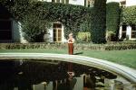 Boy, mansion, backyard, pond, ivy, bushes, garden, 1950s