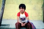 Boy Sitting on a sidewalk, Colonia Flores Magone