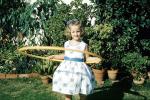 Girl, Hoola-Hoop, springtime, backyard, garden, bushes, 1950s