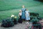 Mother with daughter and son, boy, girl, garden, bench, flowers, 1950s, PORV25P12_02