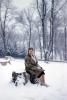 Woman Sitting in a Snowy Park, Bare Trees, Cold, Ice, Coat, Winter, 1950s