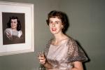 Woman Smiling with her Portrait Painting on the wall, dress, 1950s