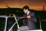 Man getting into car, evening, 1986, businessman