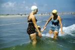 Women playing in the small waves, bathing cap, swimsuit, 1950s