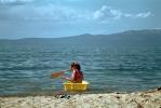 Girl on a tiny rowboat, paddle, beach, sand, Lake Tahoe, 1960s, RVLV10P04_13