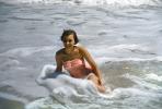 Smiling lasdy at the beach, waves, 1950s, RVLV10P12_18