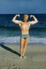 Muscle Beach, Man flexing muscles, water, sand, suntan, 1950s, SEWV01P01_07B