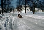 Boy on a Sled, Winter, Snow, Driveway, Suburbia, 1950s, SKFV01P07_04