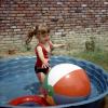 Little Girl Plays with a Big Ball, Backyard swimming pool, water, 1950s, SWFV02P10_01