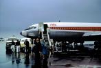 Trans World Airlines TWA, Boeing 707, stairs, rain, disembarking passengers, 1960s