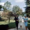 Bride walking on a sidewalk, Maid of Honor, veil, bouquet, man, woman, 1965, 1960s
